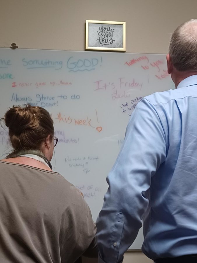 David Johns, former president, adds his good to the whiteboard with Courtney Brown, Chief of Staff. 