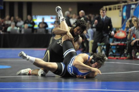 Rayshawn Dixon, junior, bends his opponent on the mat.