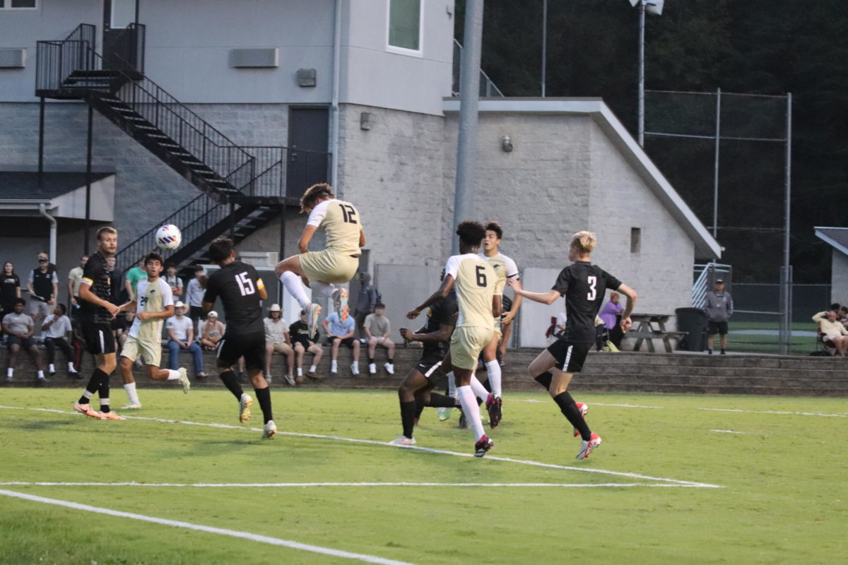 Payton Rausch, (12) sophomore, heads the ball for one of his three goals on the night. 