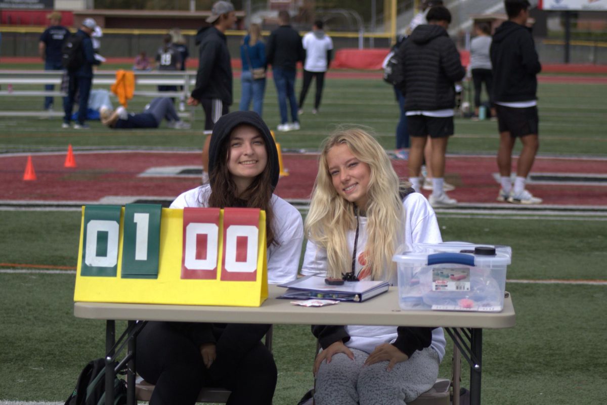 Aubrie Hixon, junior; and Jessie Howison, freshman; keep scores for the soccer game.