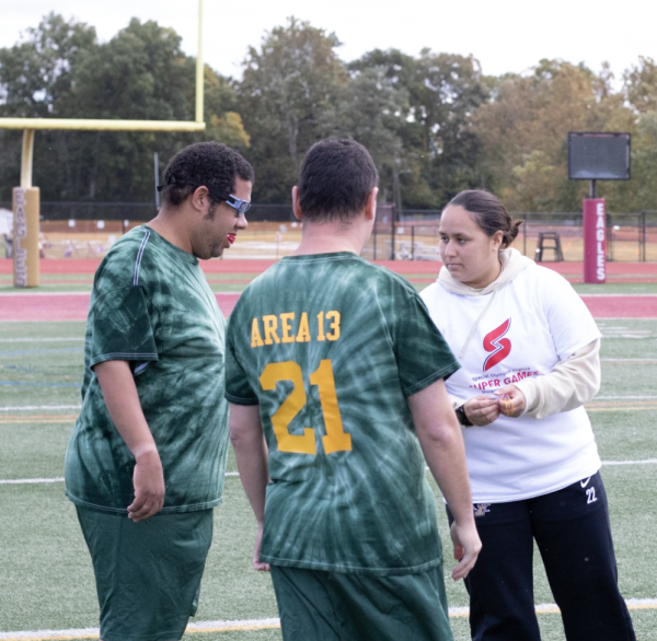 Madison Cruz, junior, instructs members of the Special Olympics Soccer Team prior to the coin toss.