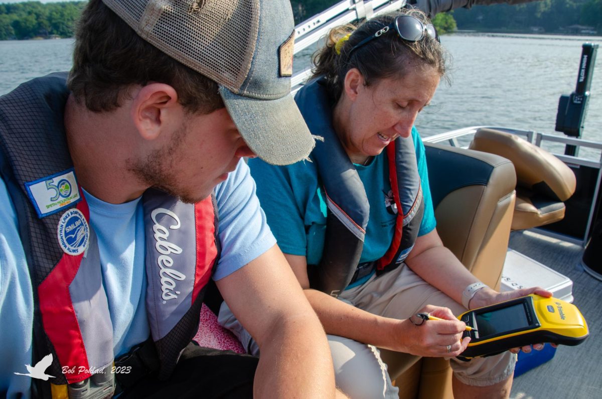 From left, Joe Presinzano, junior, and Environmental Science Professor Delia Heck examine information collected during the water quality monitoring program. 