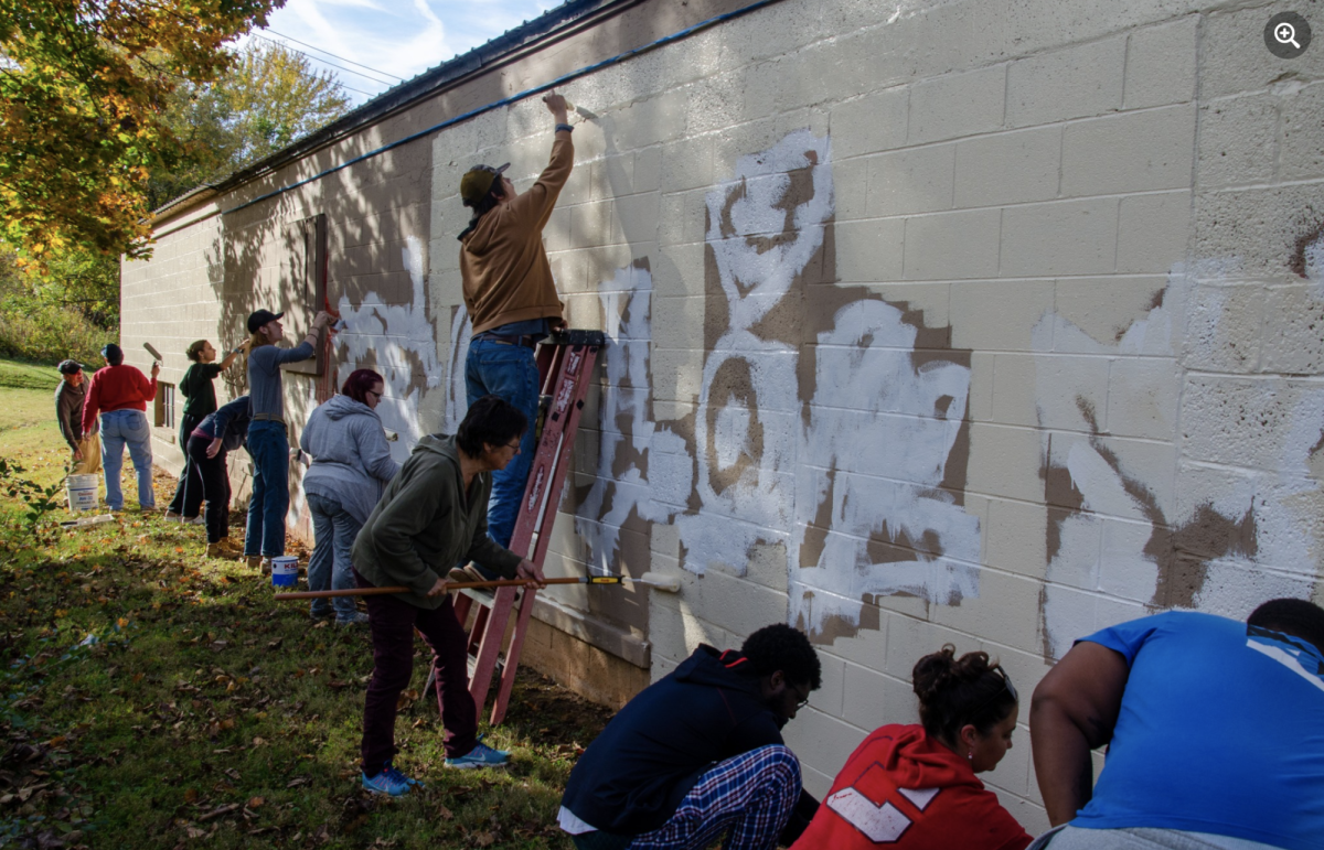 Students, staff, and community members pitch in to cover graffiti at Kats Hidden Treasures.  