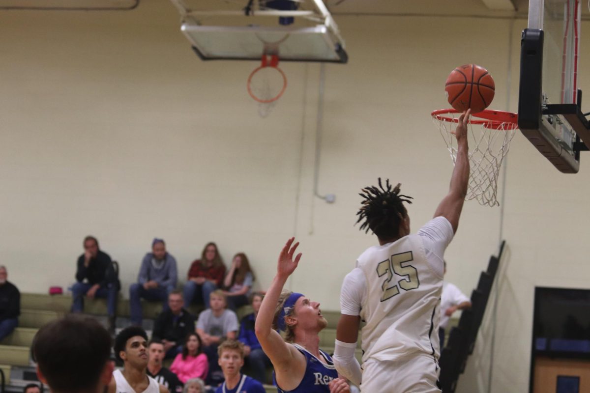 Calvin Washington, senior, tips the ball over the rim for two points in Sundays matchup against Regent.