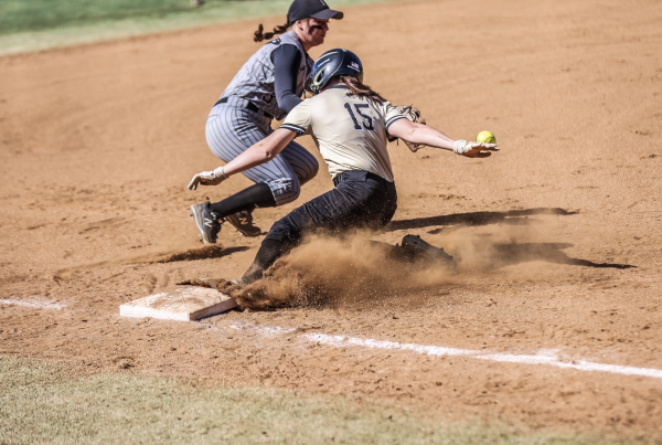 Leanna Bartrug, junior, beats the throw to third base in a game against Pfieffer.