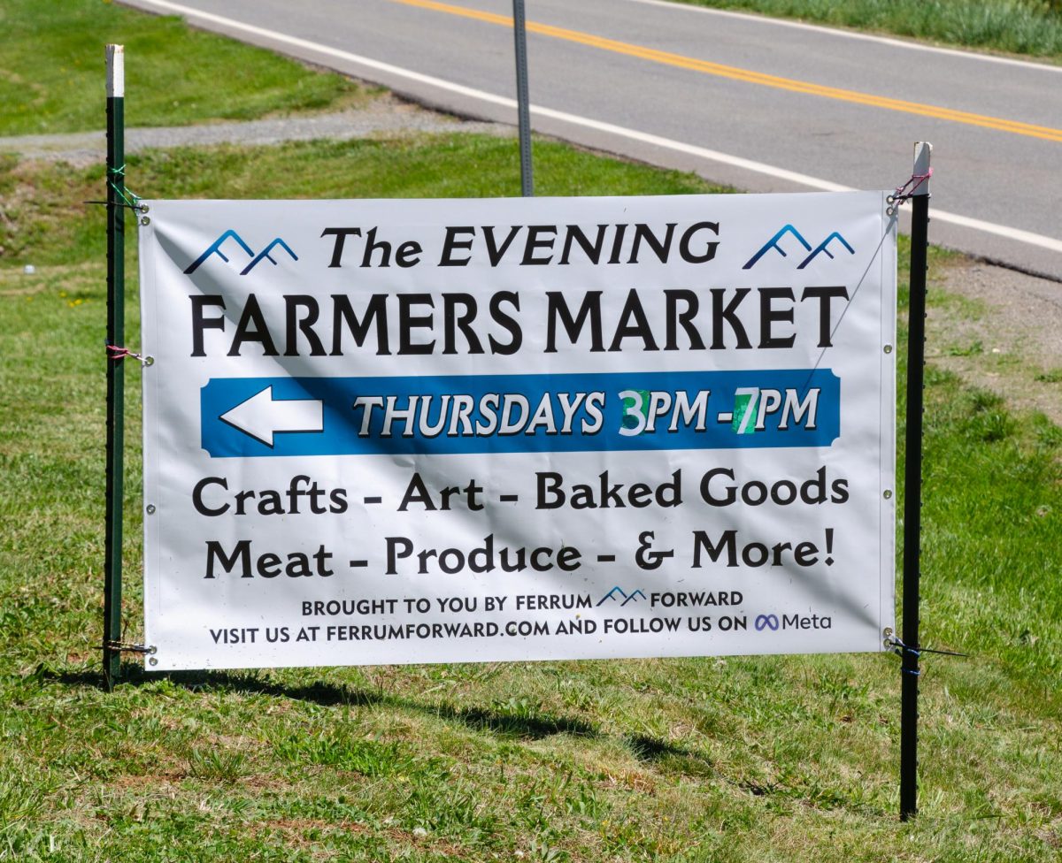 A sign directs attendees to the location of the grand reopening of the Farmers Market.