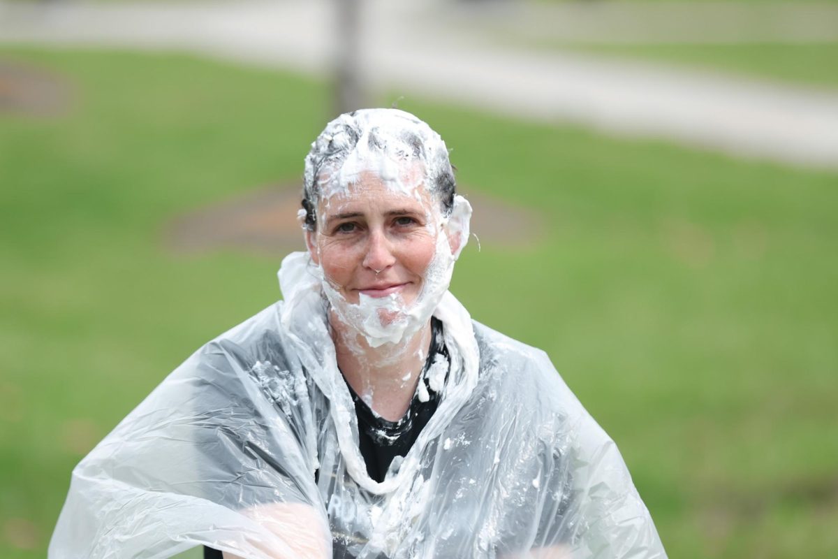 Head Womens Soccer Coach Erin Saleeby peeks through the Cool Whip for a quick photo after being pied.