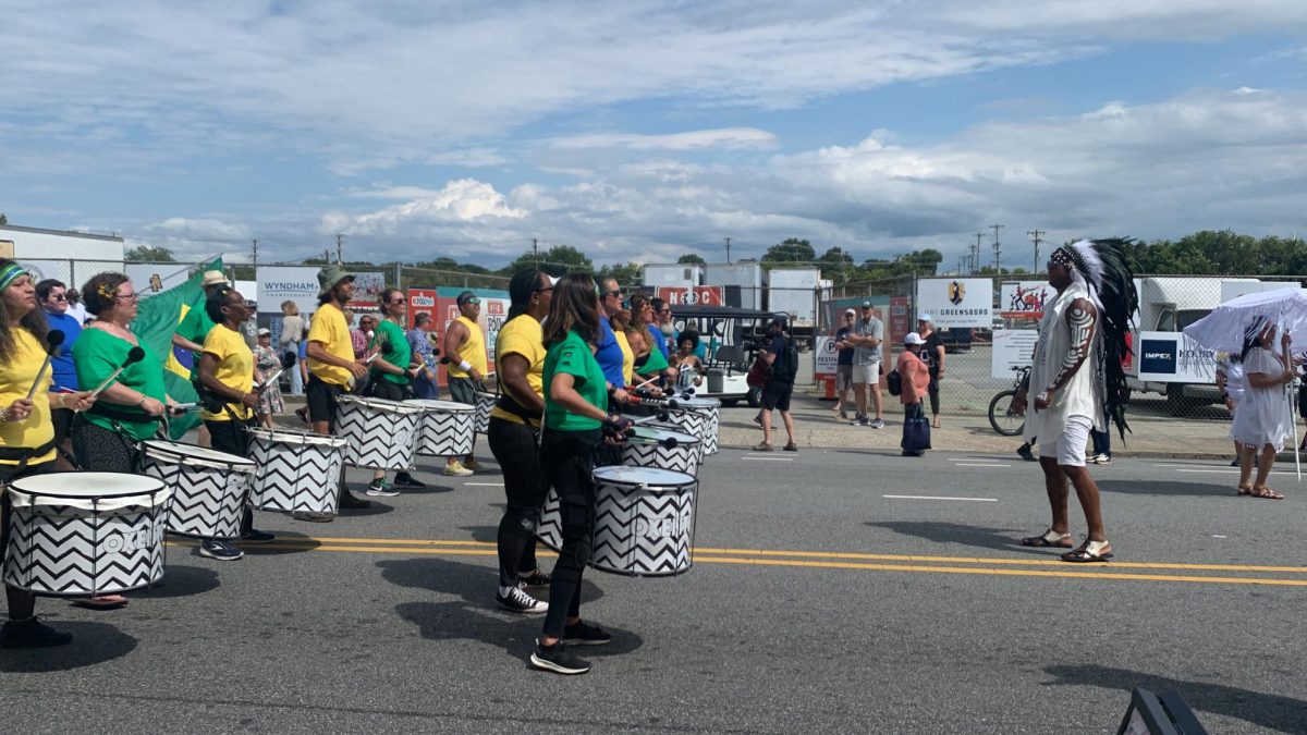 The Brazilian Drum Line stands ready to march, awaiting the command from their drum major, right.