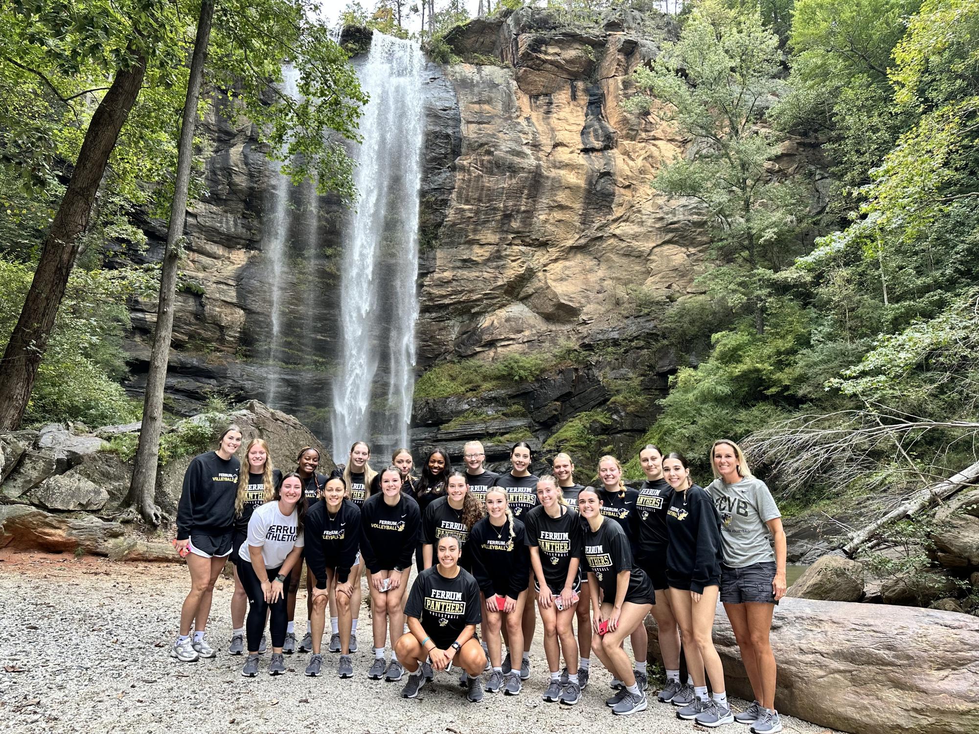 The Panther volleyball team stands in front of the Toccoa Falls waterfall on the campus of Toccoa Falls College.