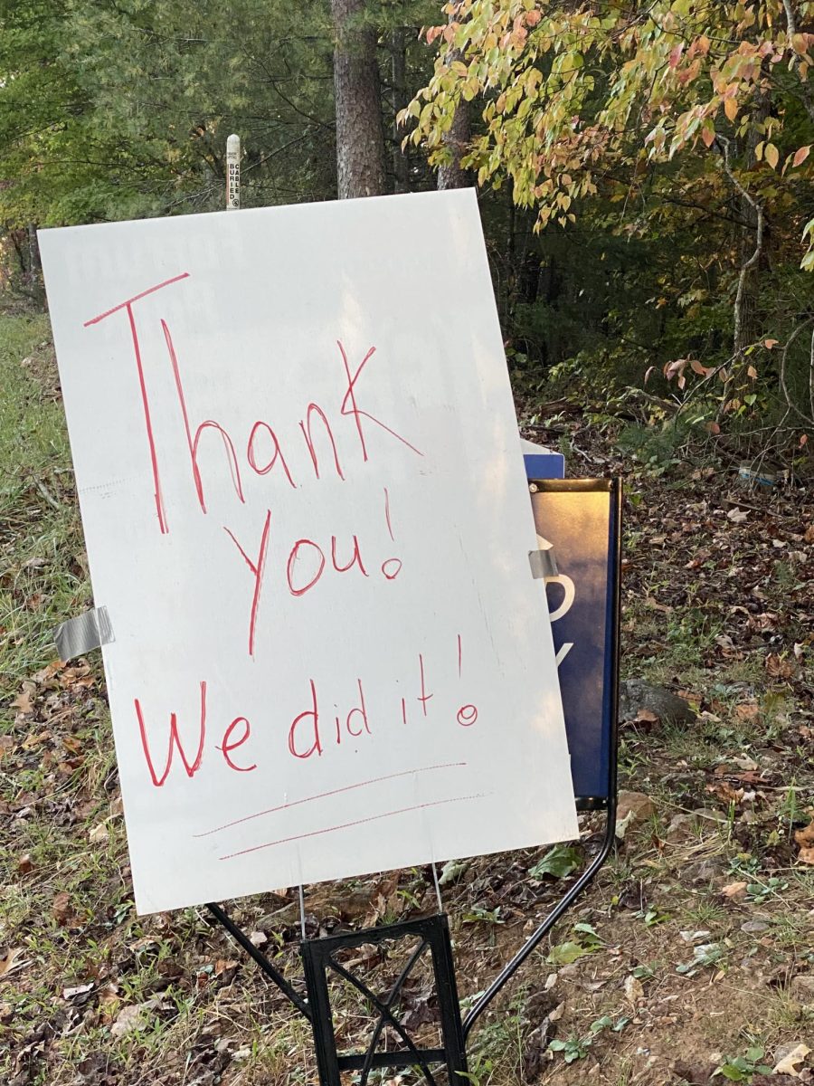 A hand-written sign hangs over the Ferrum Forward sign announcing that Friends of Ferrum Park raised enough money to purchase the land for the park.