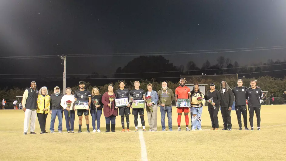 From left, seniors Erick Nolasco, Jaedyn McKinney, Callum Harrison, and MJ Upchurch, stand alongside their families while being honored for senior night.