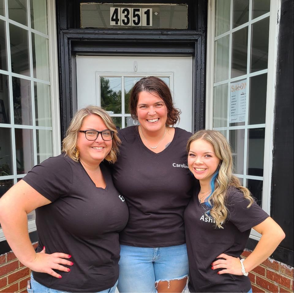 From left: Erica Austin, Caroline James, and Ashley Bondurant proudly pose at the steps of their salon, ready to add a touch of beauty to the Village.