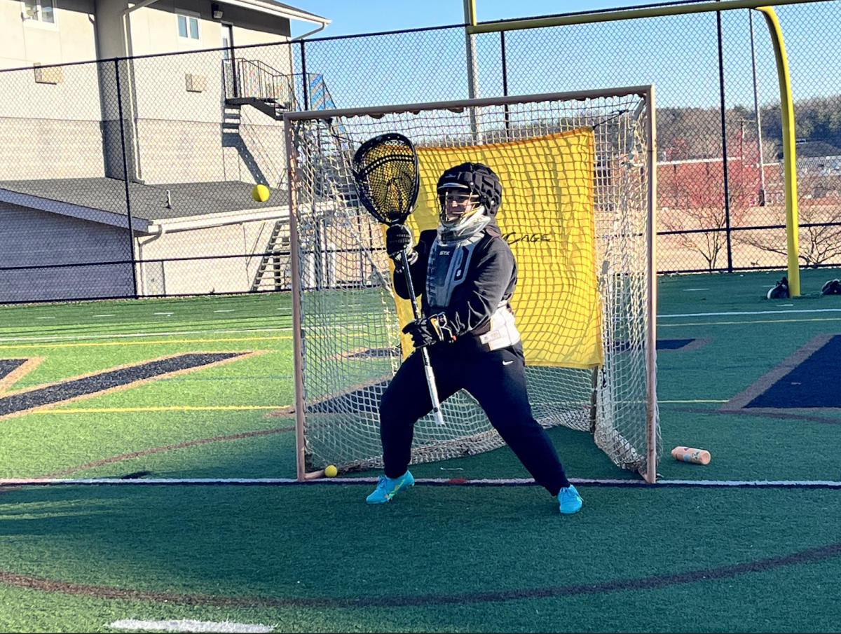 First-year LAX goal keeper Cayden West prepares to stop the ball as she guards the net. 