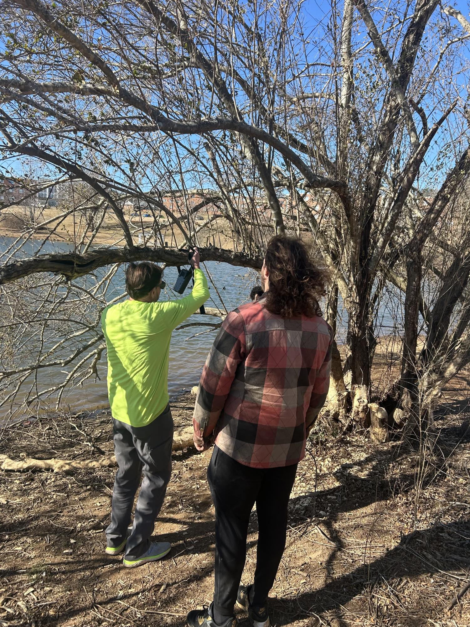 From left, Forestry and Wildlife Professor Todd Fredericksen and Trent Ray, senior, set up a trail camera by Adams Pond.