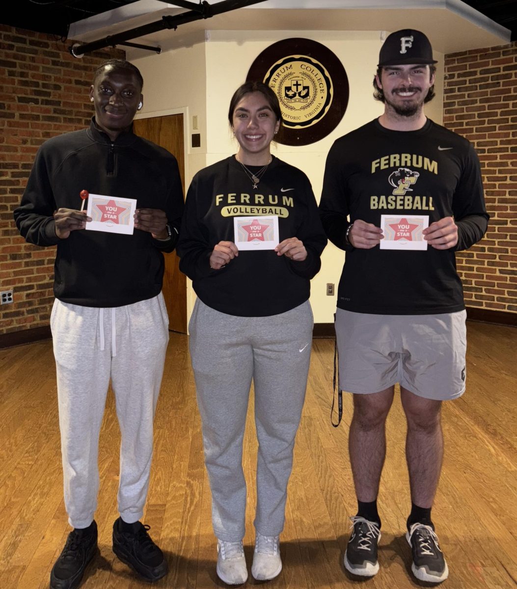 From left, Aukiem Mitchell, junior; Sami Kircher, senior; Dylan Amend, sophomore; are awarded with prizes after placing in Trivia Night.