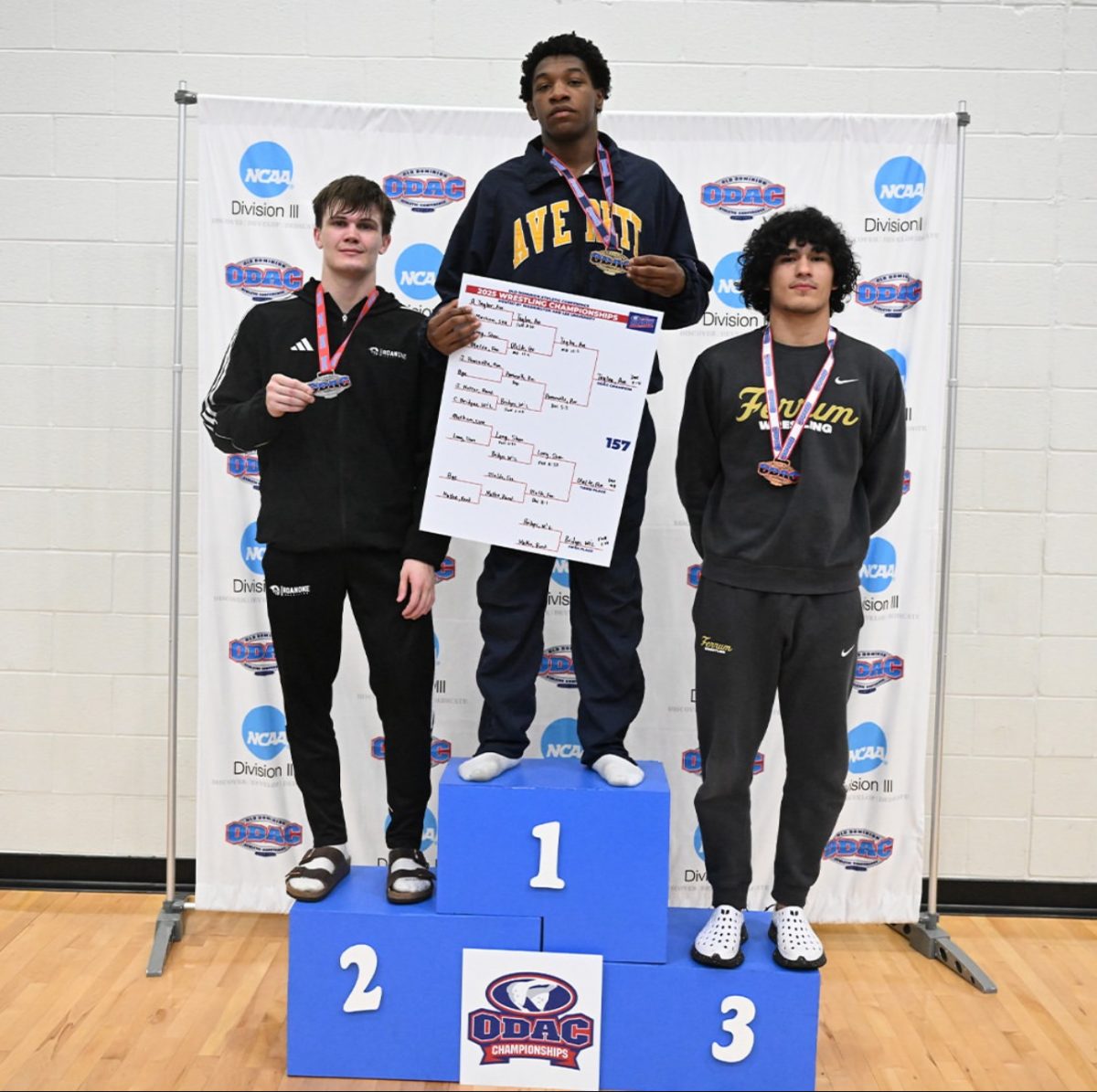 At right, Joseph Olalde, junior, stands on the podium with his third-place medal at the ODAC Championship.