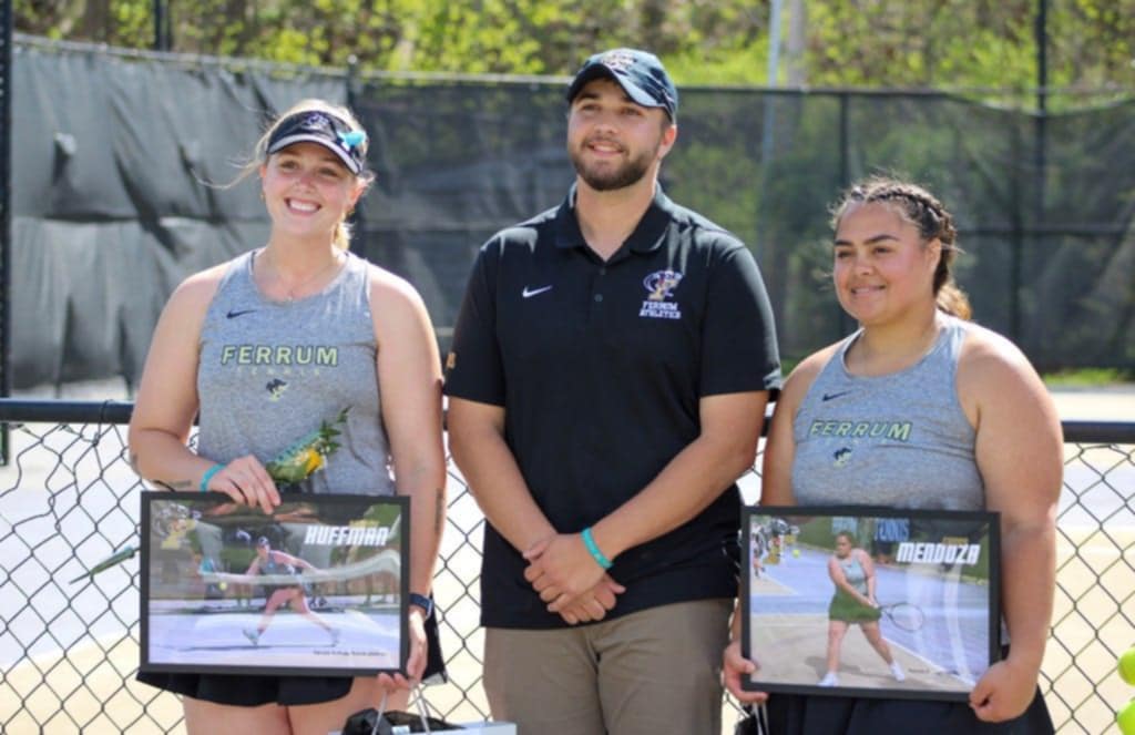 Hannah Huffman and Gabby Mendoza pose for a picture with Coach Noah Hughes after their game.