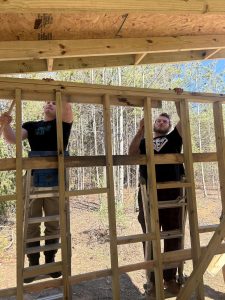 From left to right; Michael Oliver, senior, and Trent Ray, senior, hammer a board into place on Ferrum Park's new shed.