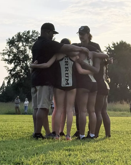 The women's cross country team huddles together for a pep talk with the coaches before taking off at the Converse Kickoff. 