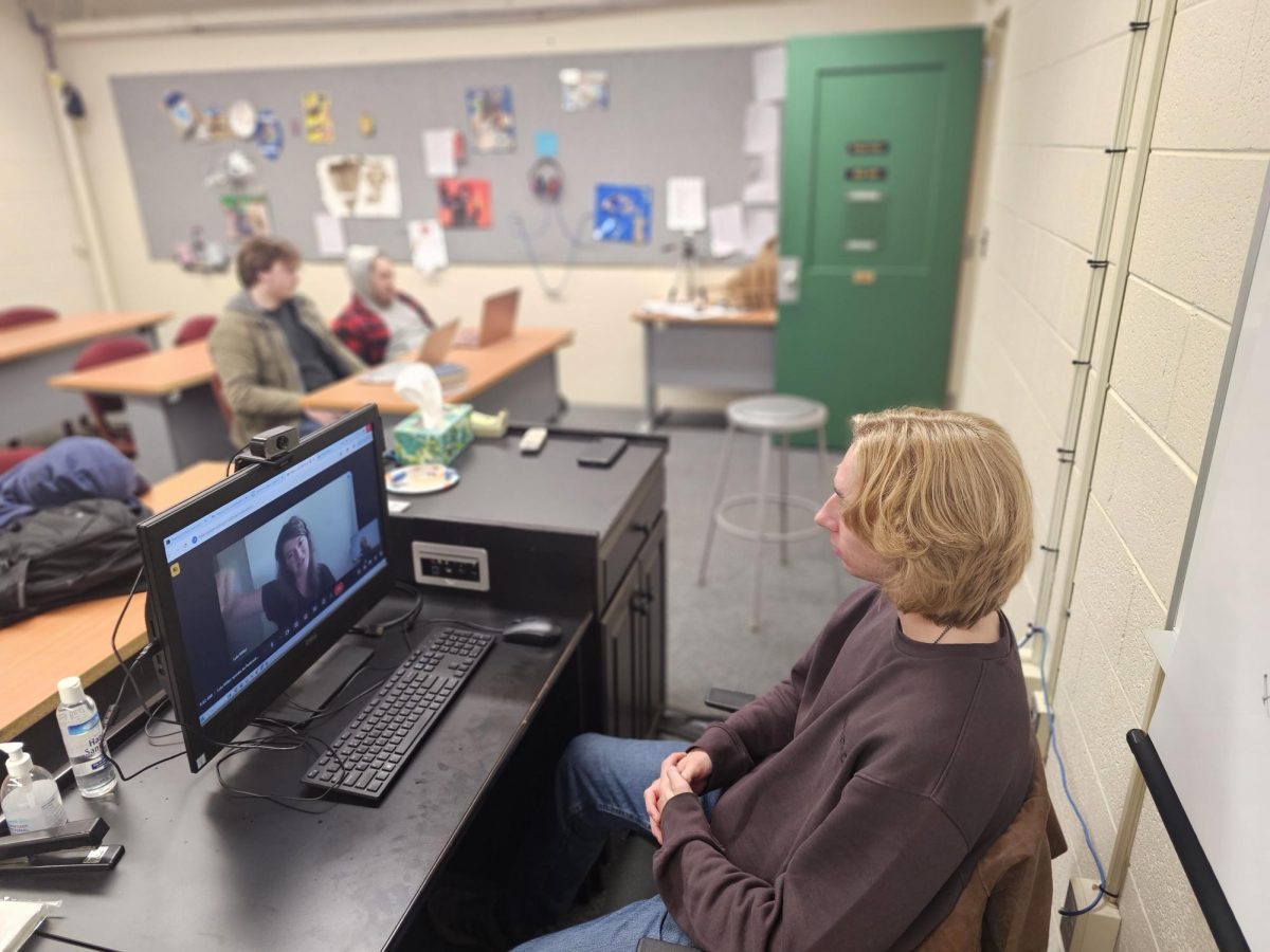 Senior Stone Gibbs speaks to NPR team member Lulu Miller over zoom while other students prepare their questions. 