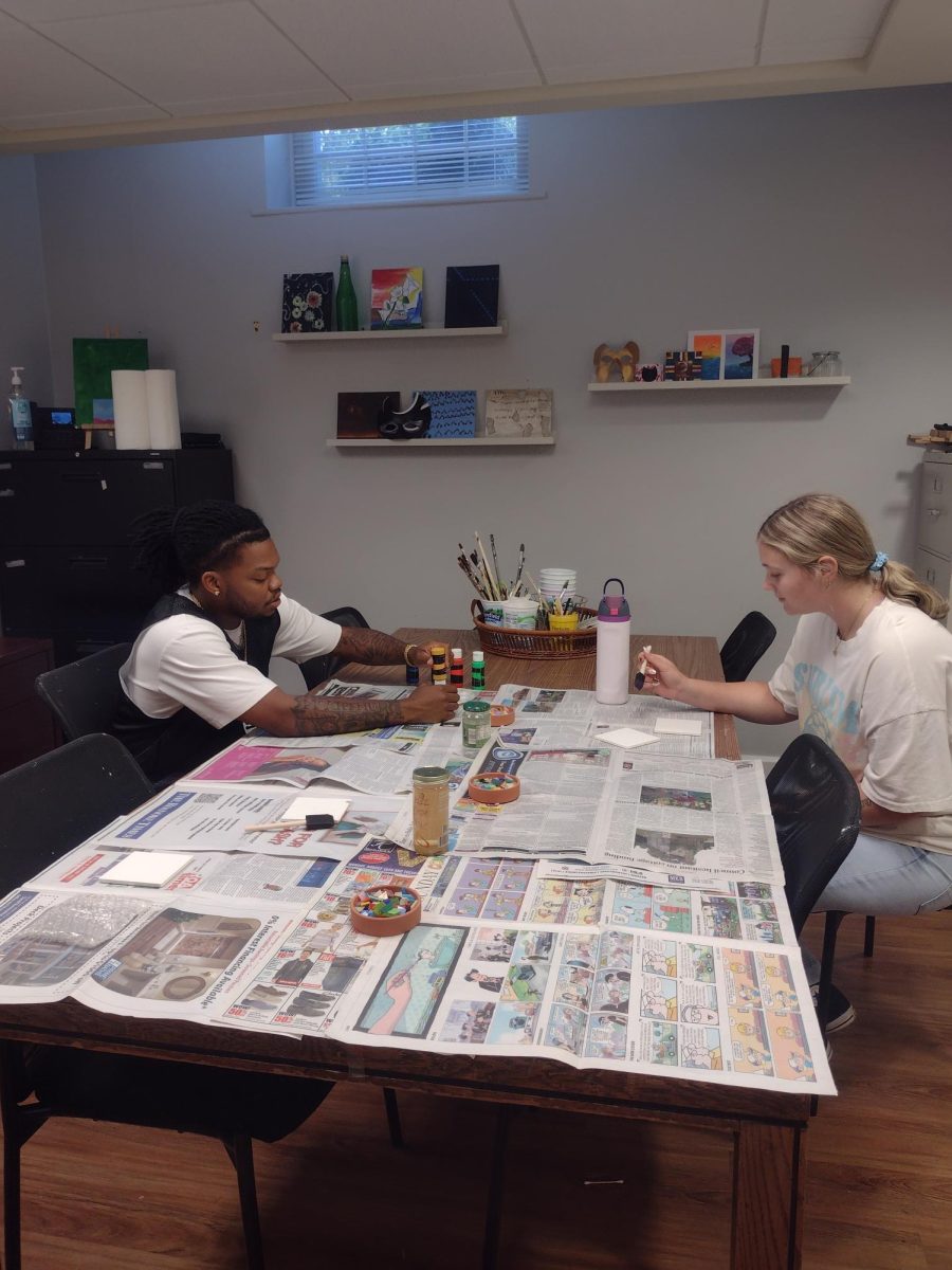 From left, EJ Mcarthur, senior, and Hannah Huffman, grad-student, paint coasters in the art room.