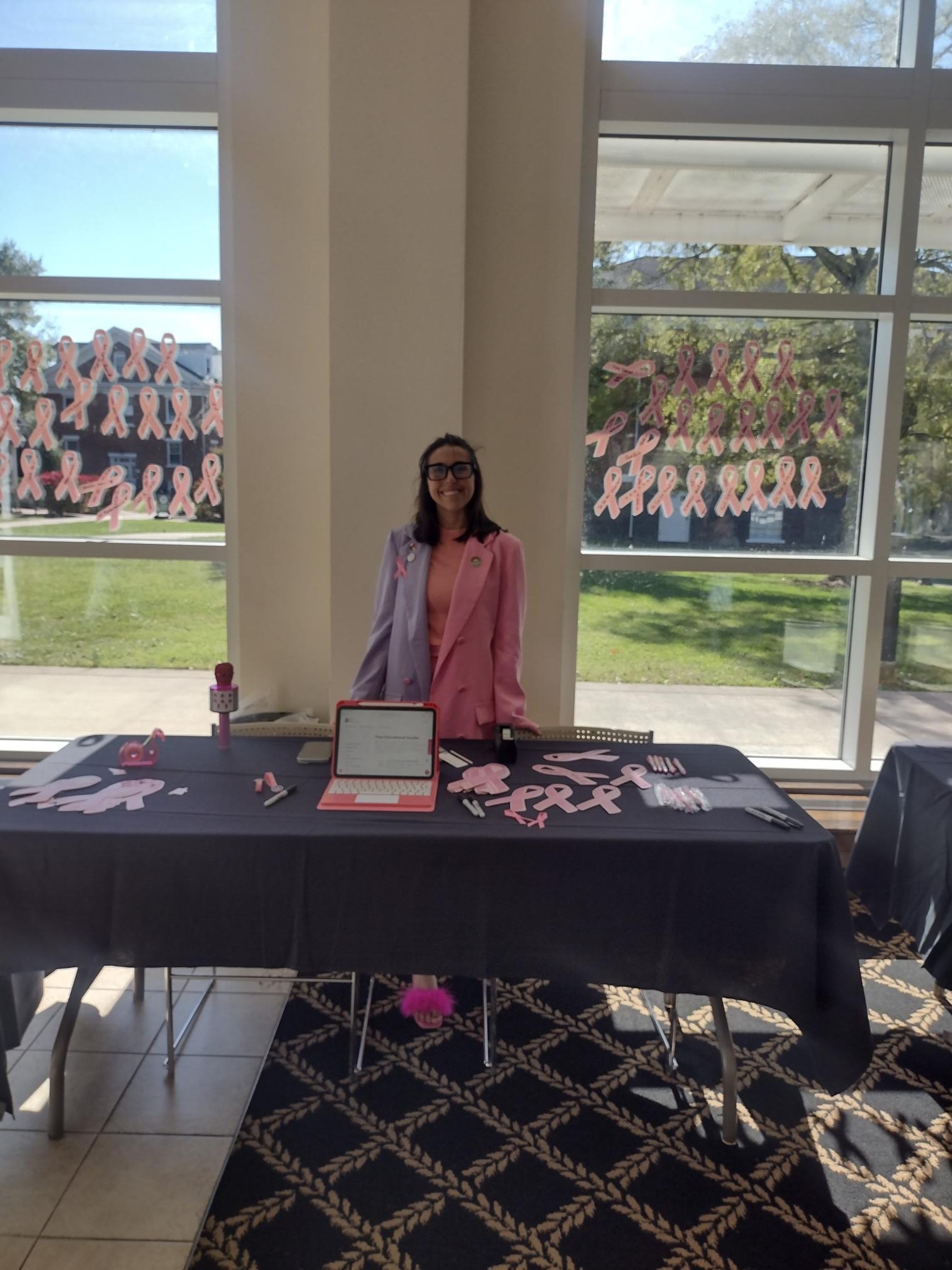 Student Wellness & Title IX Coordinator, Kamrin Mitchell, stands in Franklin Hall giving out information about breast cancer.