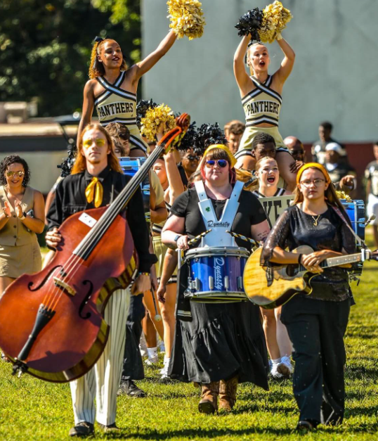 Senior Sarah Gallagher, center; junior Django Burgess, at left; and alumni Emily Walker, right; lead the band in formation.