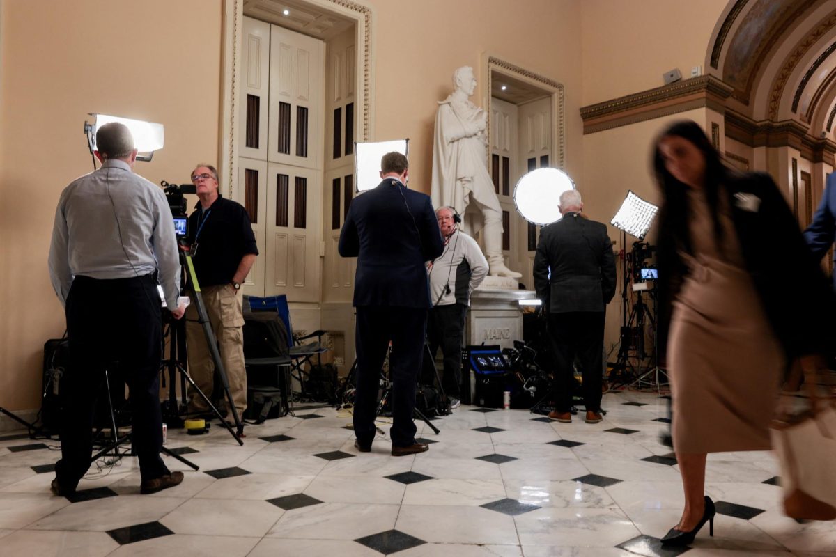 Reporters and members of Congress participate in live TV segments before the U.S. House of Representatives begins voting on the release of the Epstein files.