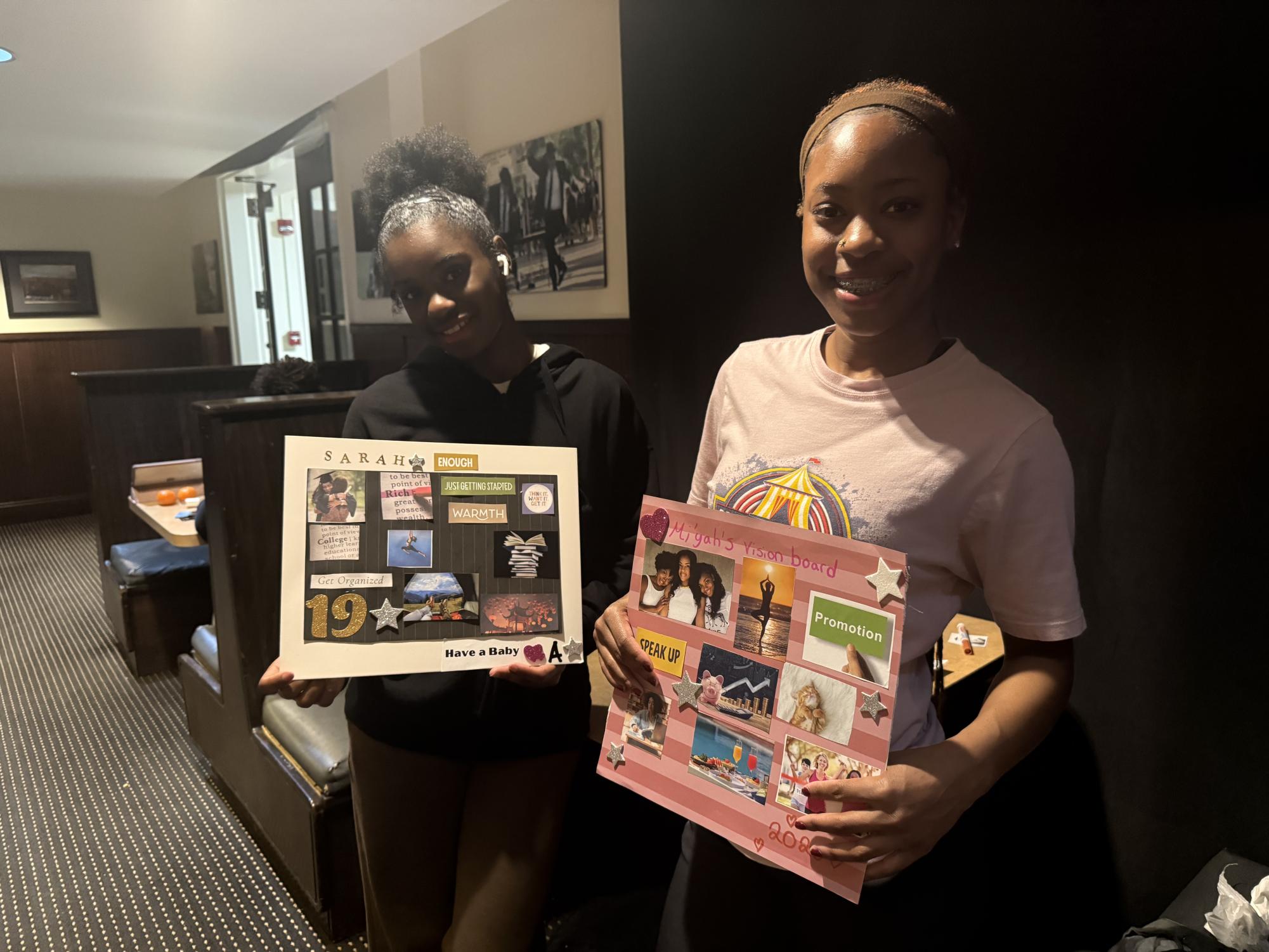 First-years Sarah Hudgins and Mi'yah Young hold their vision boards. 