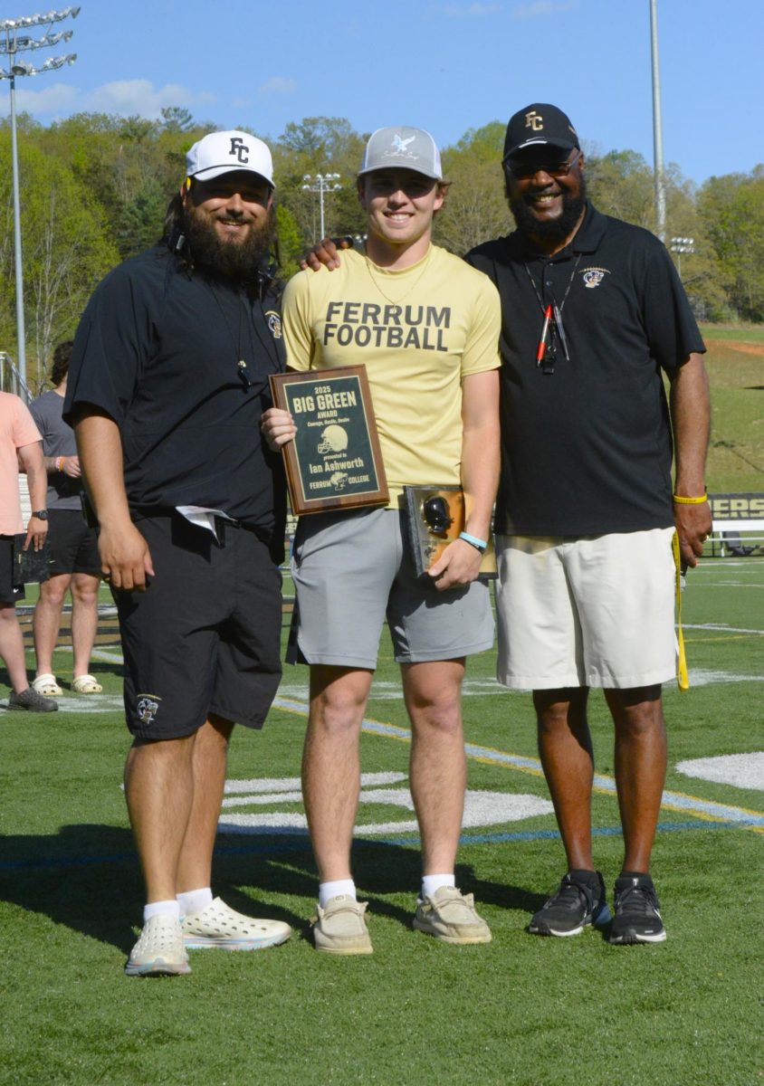 Ian Ashworth, center, poses with coach Kevin Sherman, left, and former winner Anthony Konieczka, right, after receiving the 2026 Big Green Award during Ferrum’s spring game April 11.